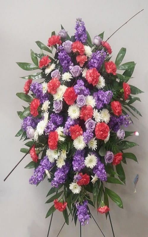 Standing floral spray with purple, red, and white flowers on an easel