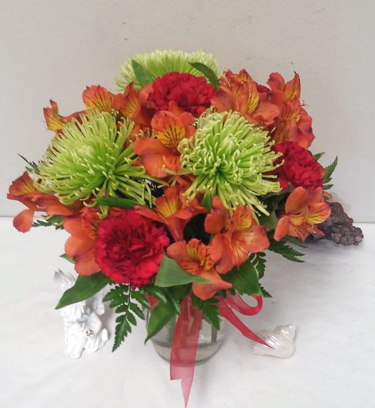 Bouquet of orange alstroemeria and red carnations in a glass vase