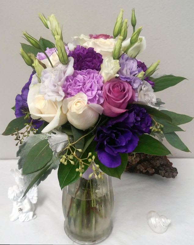 Bouquet of purple, pink, and white flowers in a glass vase