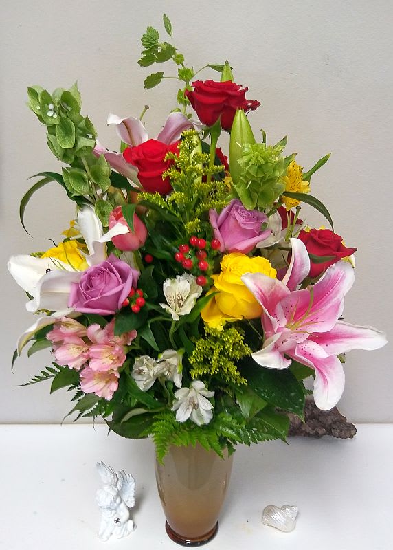 Mixed bouquet of roses and lilies in a glass vase