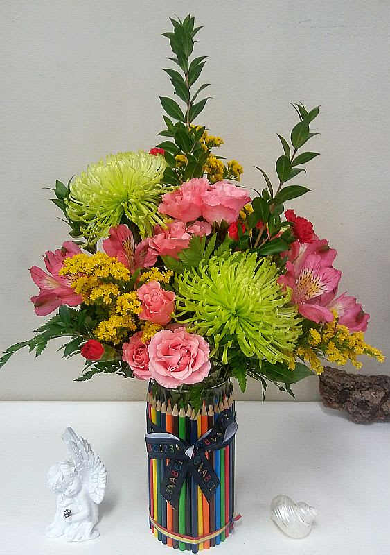 Colorful bouquet of pink and green flowers in a pencil-decorated vase