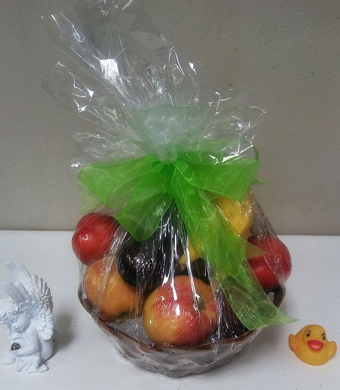 Wrapped fruit basket with a green bow and small decorative figurines