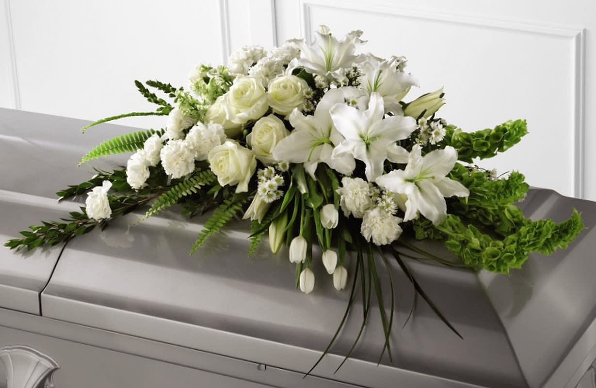 White floral casket spray with lilies and roses