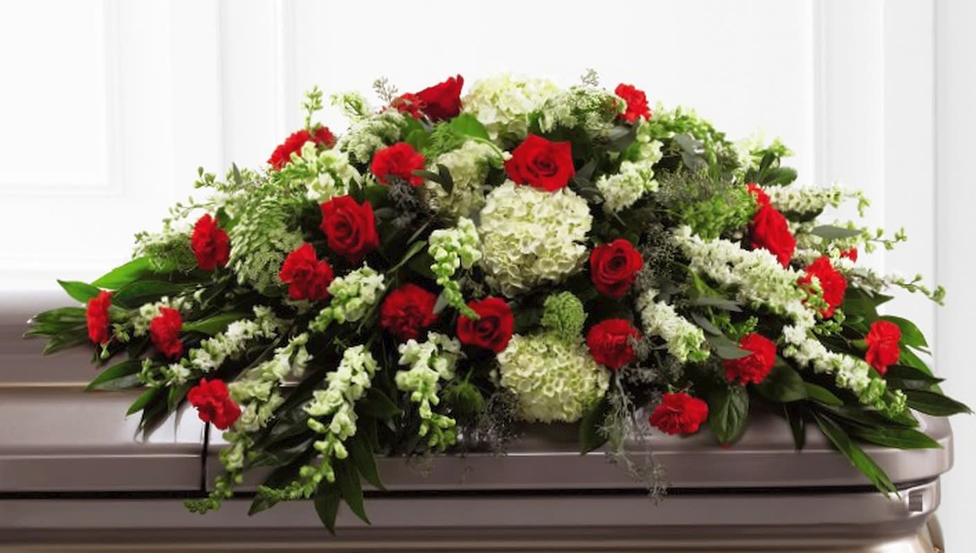 Red roses and white flowers arranged on a casket