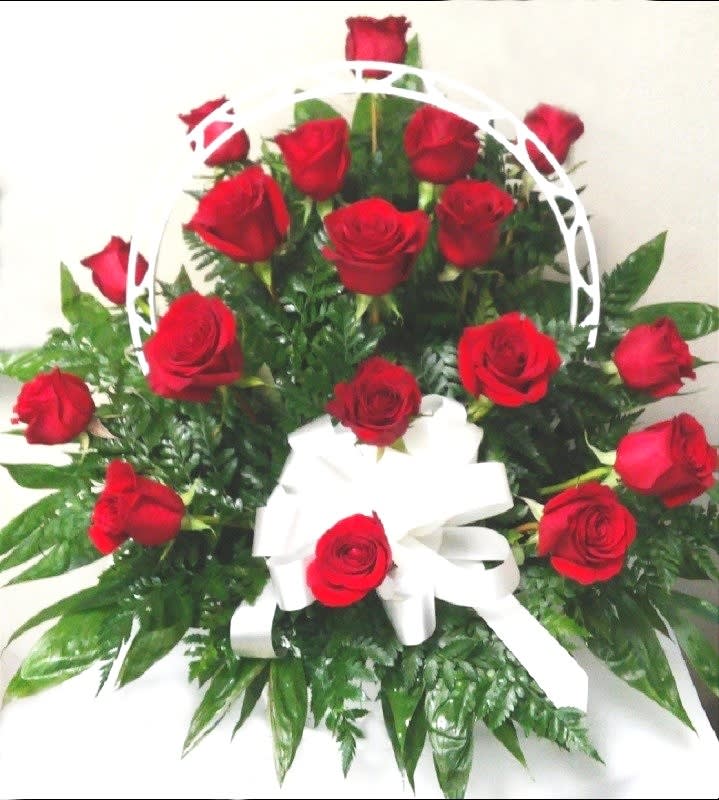 Basket arrangement of red roses with a white ribbon bow