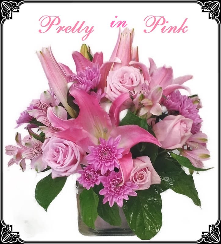 Pink floral arrangement in a glass vase with roses and lilies