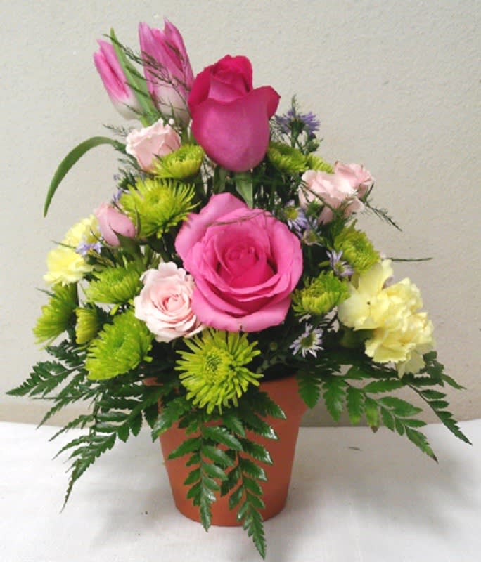 Pink and yellow mixed flower arrangement in a terracotta pot