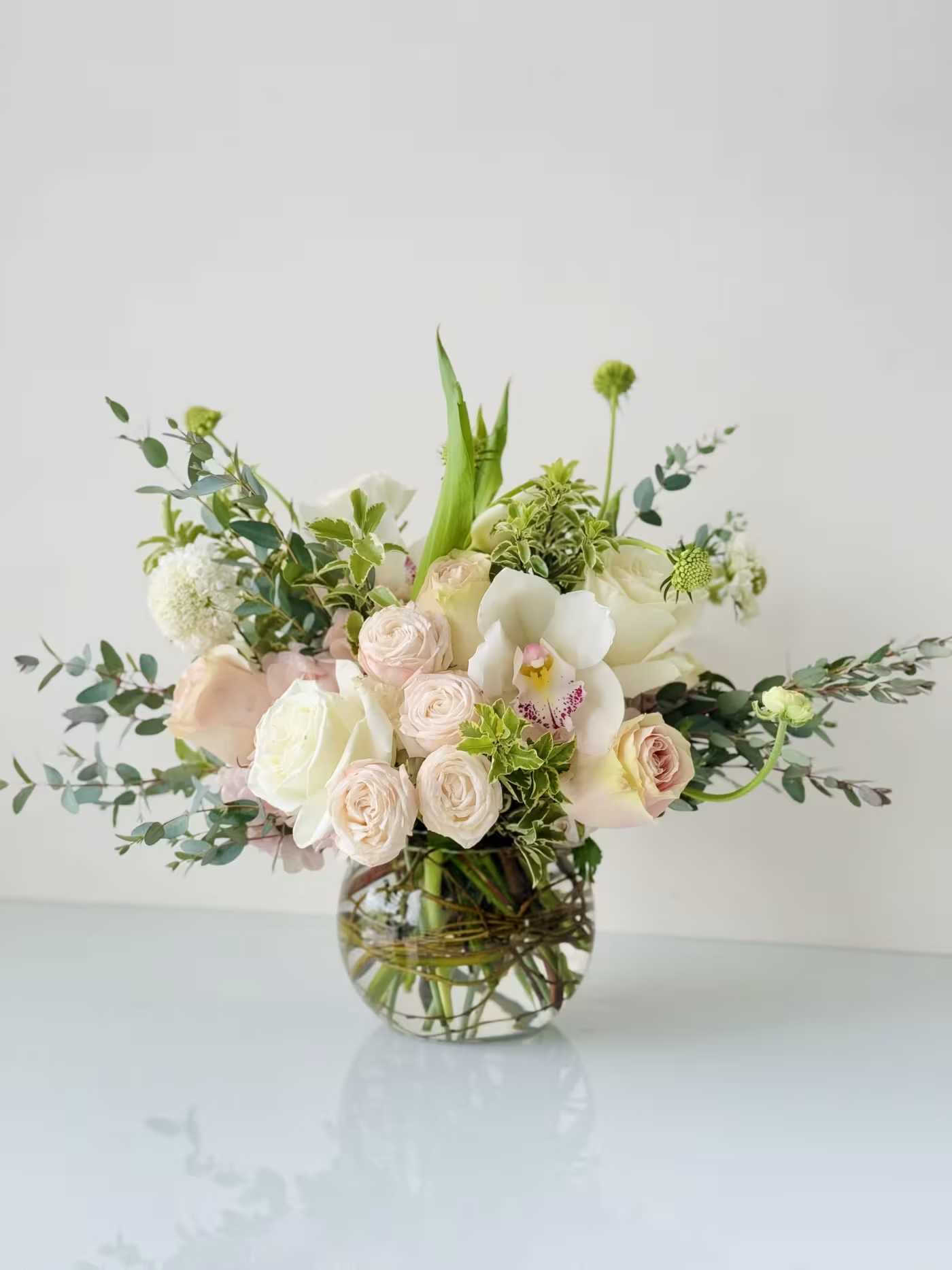 Blush and white floral arrangement in a clear glass vase