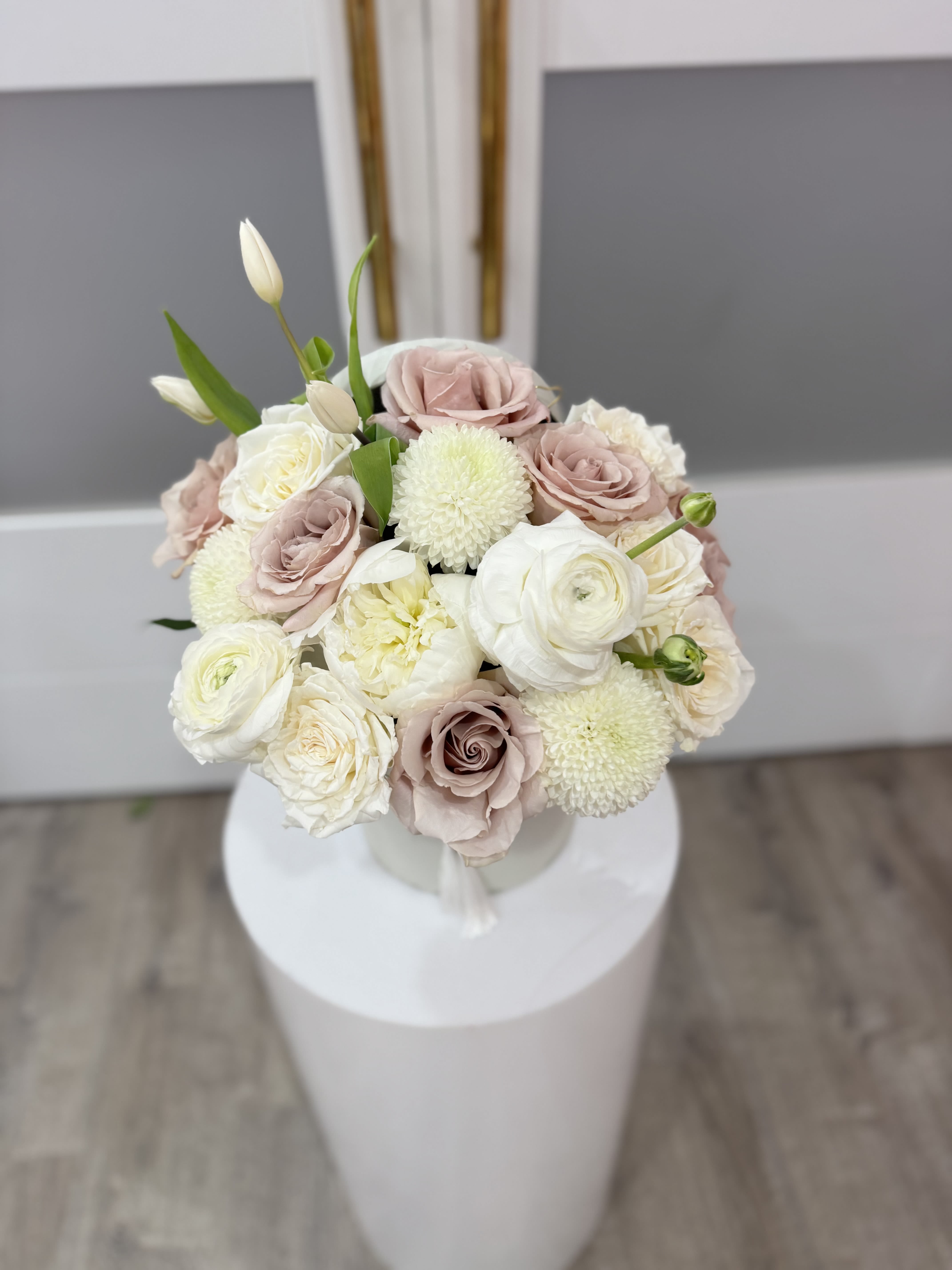 Bouquet of blush and white roses with round white blooms in a vase