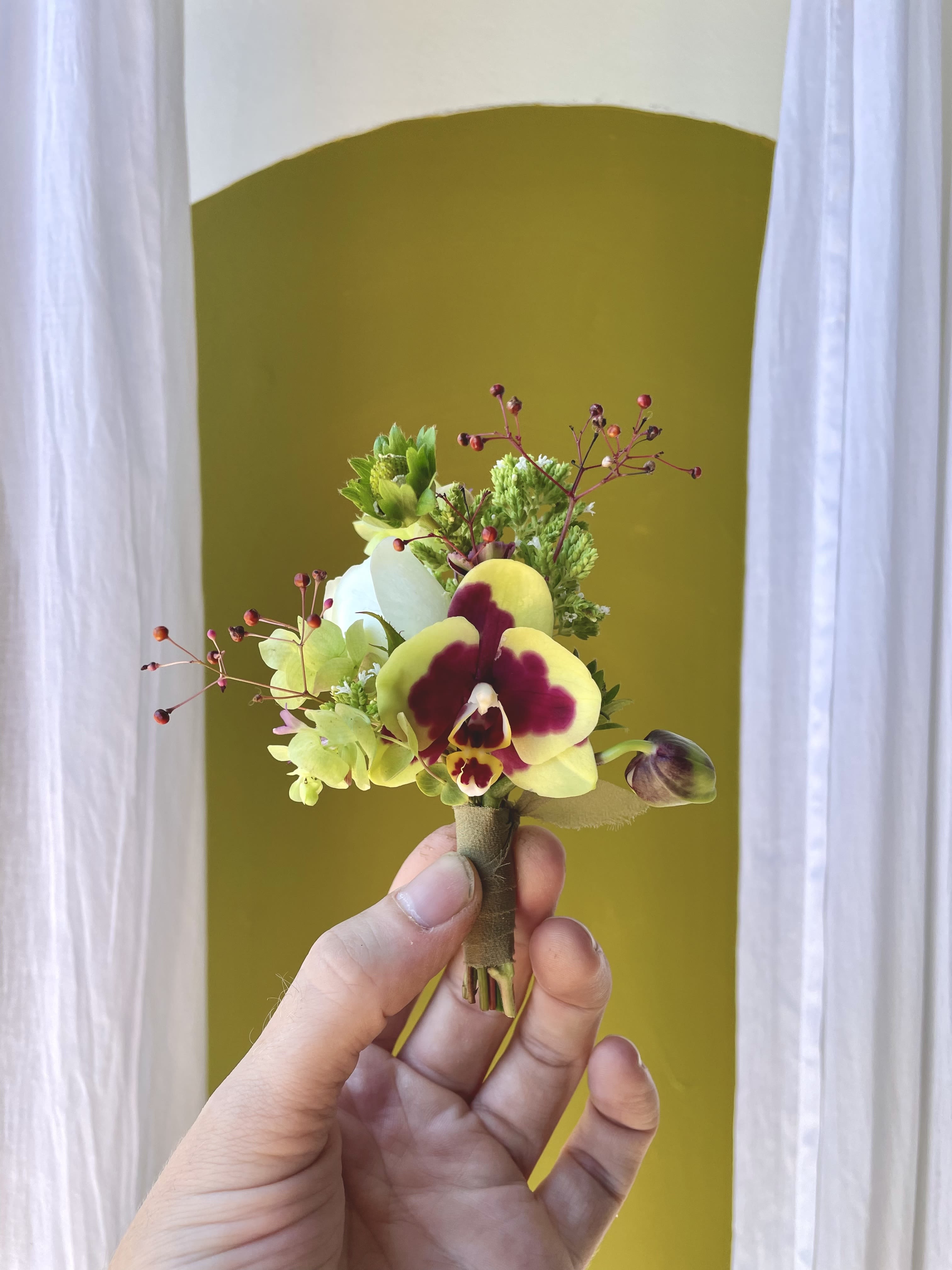 Boutonnière  - This is our classic Papillon boutonnière. We gather a fun, unique, and interesting selection of foliage and blooms and wrap them with a matching ribbon complete with pins to attach to clothing. These are wonderful for prom and other special events.   When ordering, please leave us a note under “special instructions” with the desired color palette for your boutonnière.  And your preferred ribbon color   This item is pickup only between  — please let us know in the notes what time you’ll be picking up. 