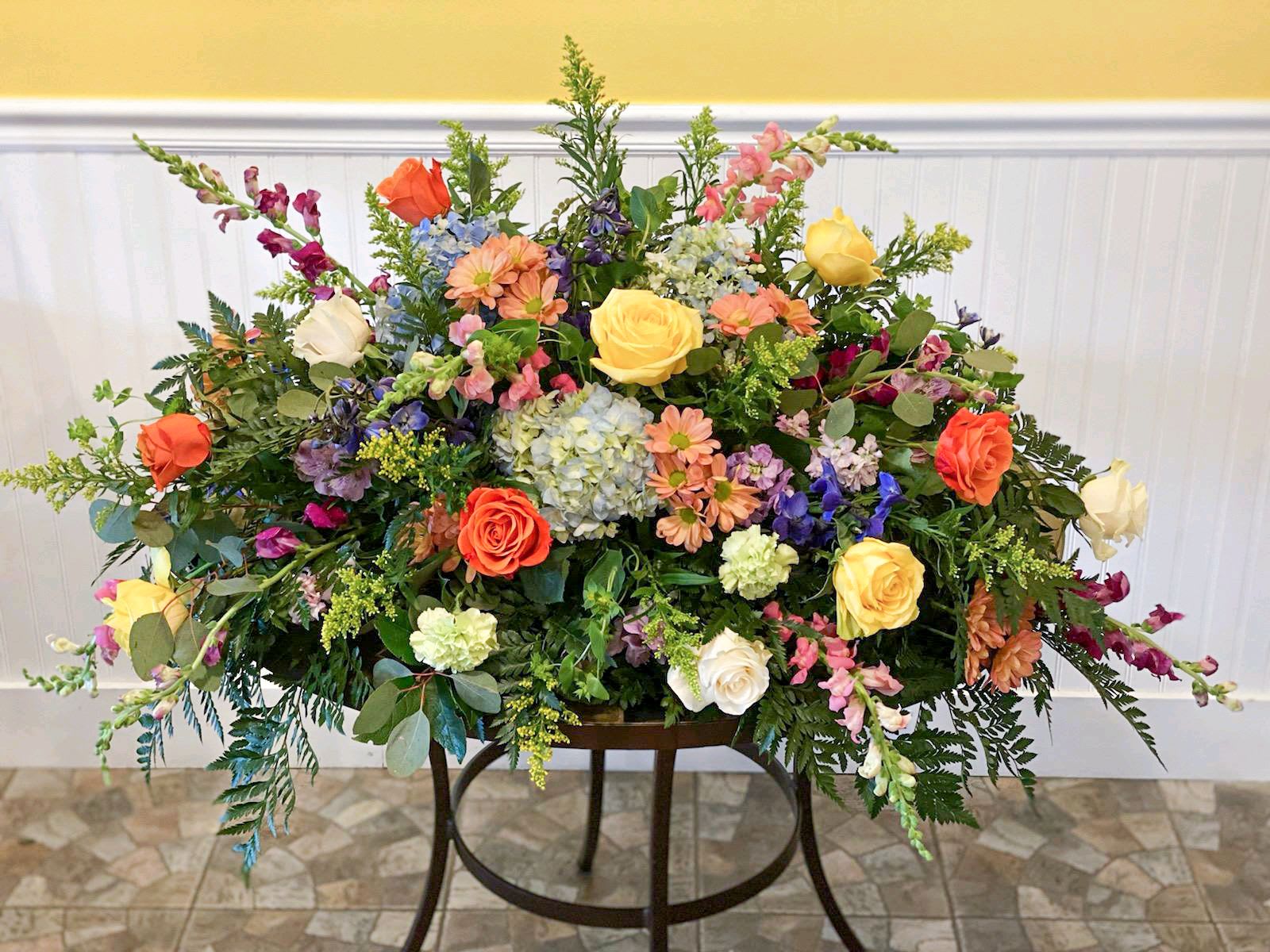 Large mixed floral arrangement with roses, hydrangeas, and snapdragons