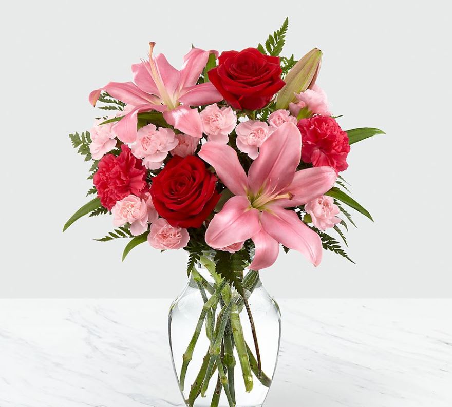 Heart's Emotions Bouquet - VASE INCLUDED - Picked fresh from the farm, the Heart's Emotions Bouquet sends graceful blooms to your special someone, sweeping them off their feet with each blushing blossom! Gorgeous red roses, hot pink mini carnations, pink mini carnations, pink LA Hybrid Lilies, and lush greens are brought together to create a flower arrangement exuding the riches of romance. Presented without a designer ruby red glass vase, this exquisite mixed flower bouquet will convey your heart's every emotion in celebration of this coming February 14th. BETTER bouquet includes 8 stems with vase. Bouquet is approximately 16"H x 14"W.  