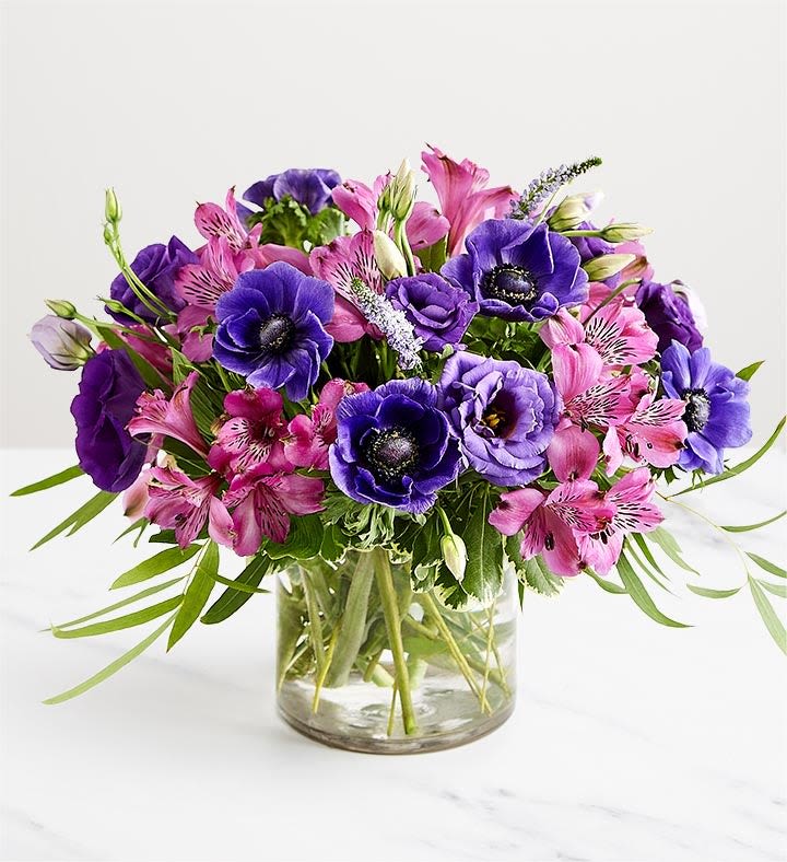 Purple and pink mixed bouquet in a clear glass vase