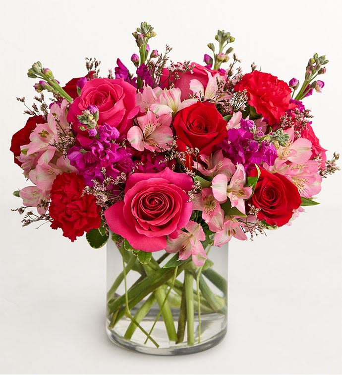 Bouquet of pink and red roses with alstroemeria in a clear glass vase