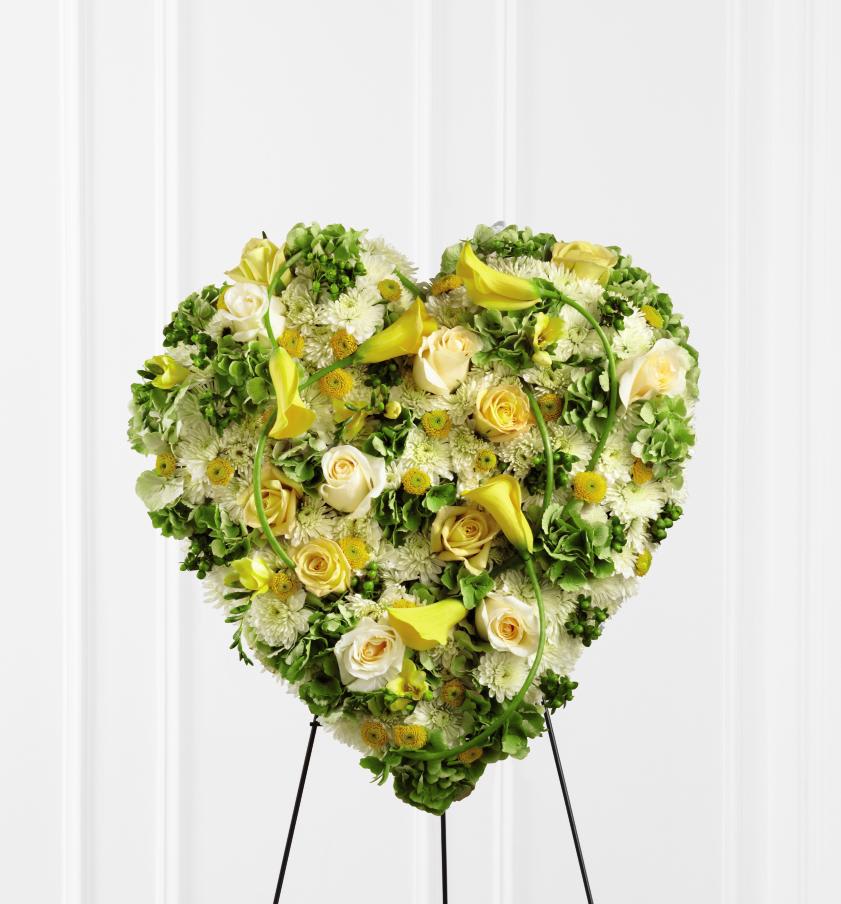FTD Glowing Ray Standing Heart - The FTD Glowing Ray Standing Heart is an exquisite way to show   your love and affection for the deceased. A collection of sunlit blooms,   including, yellow roses, freesia, mini calla lilies, and button poms   are accented with green hydrangea, white chrysanthemums, cream roses and   green hypericum berries to form a sophisticated heart-shaped   arrangement that offers a bright and elegant expression of caring   kindness for their final goodbye. Displayed on a wire easel.      24h x 20w