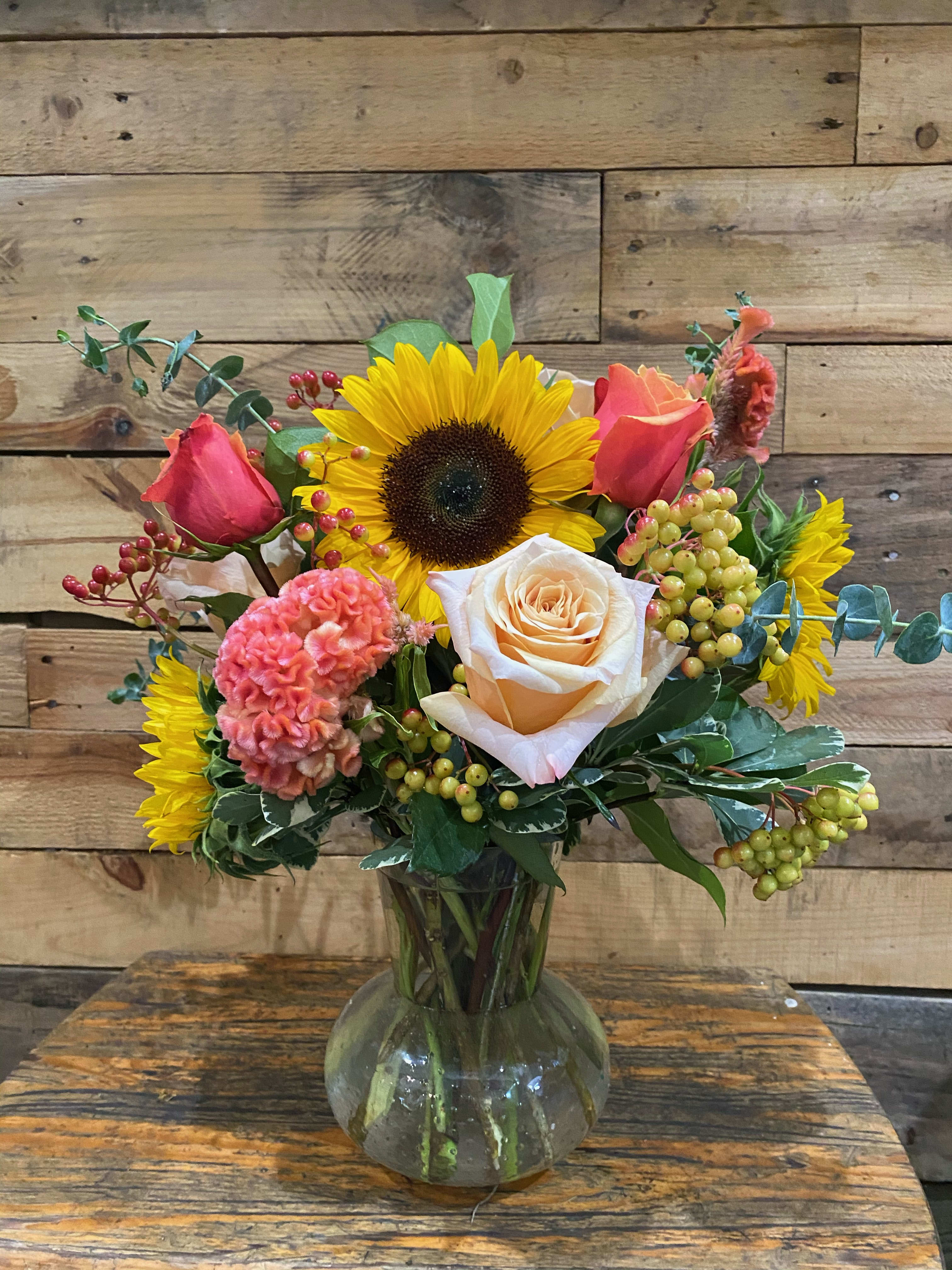 Peach Cobbler - Our arrangment includes sunflowers, and peach roses in a clear vase.  Substitutions may be applied
