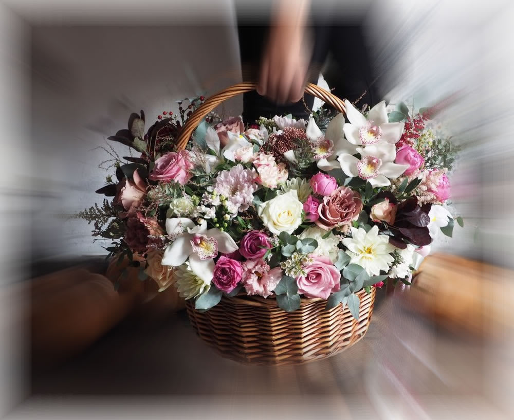 Basket of pink and white mixed flowers with orchids and roses