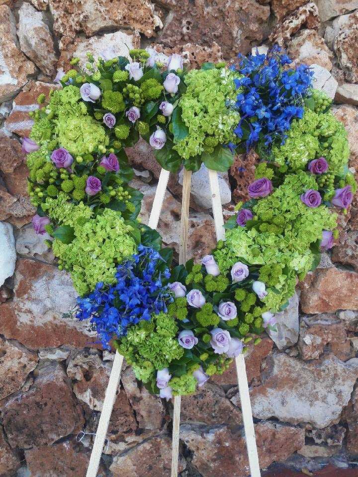 Heart-shaped floral wreath with green hydrangeas, purple roses, and blue flowers
