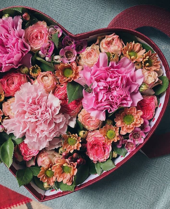 Heart-shaped box of pink and peach flowers