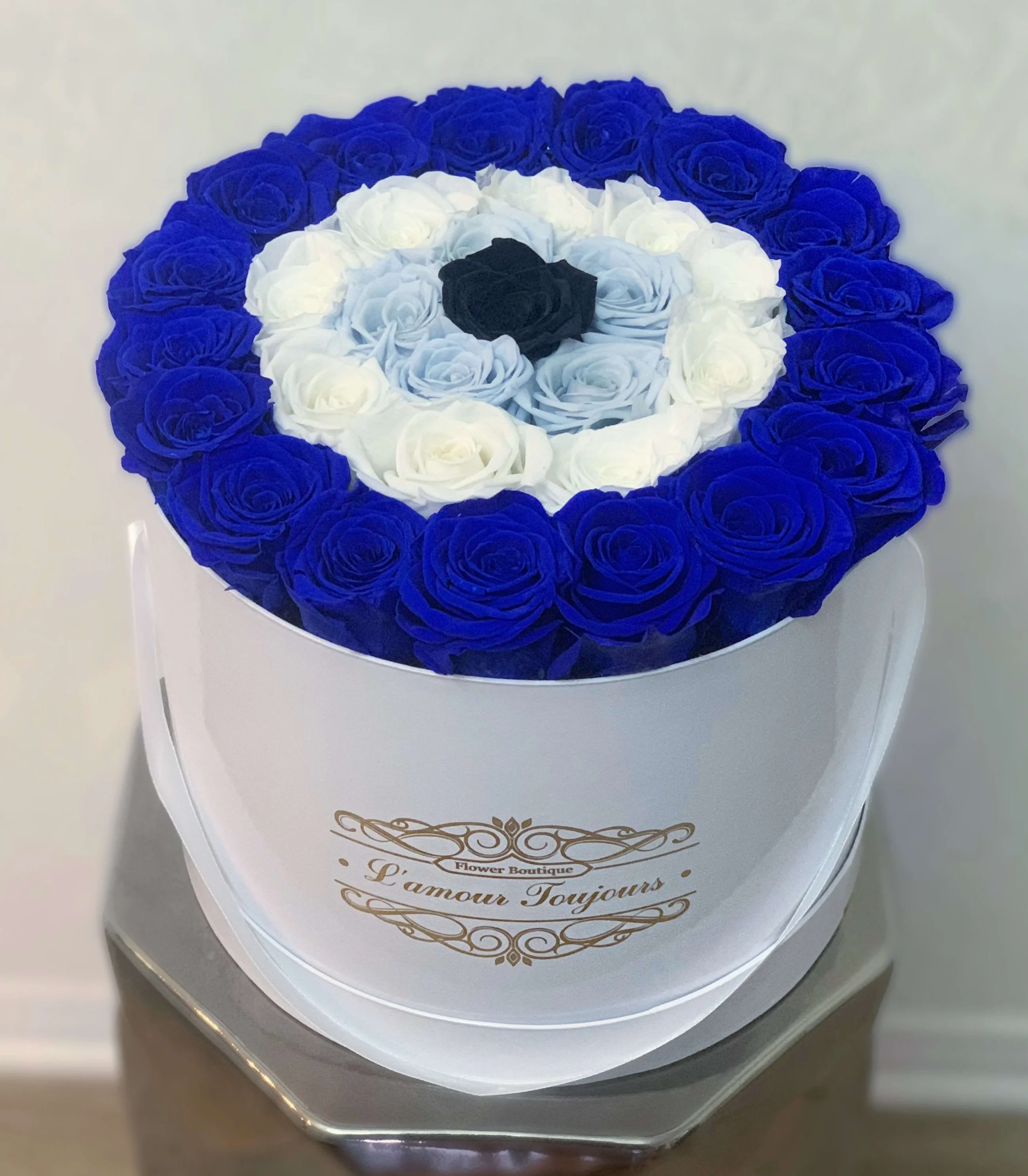 Round box of blue, white, and black roses