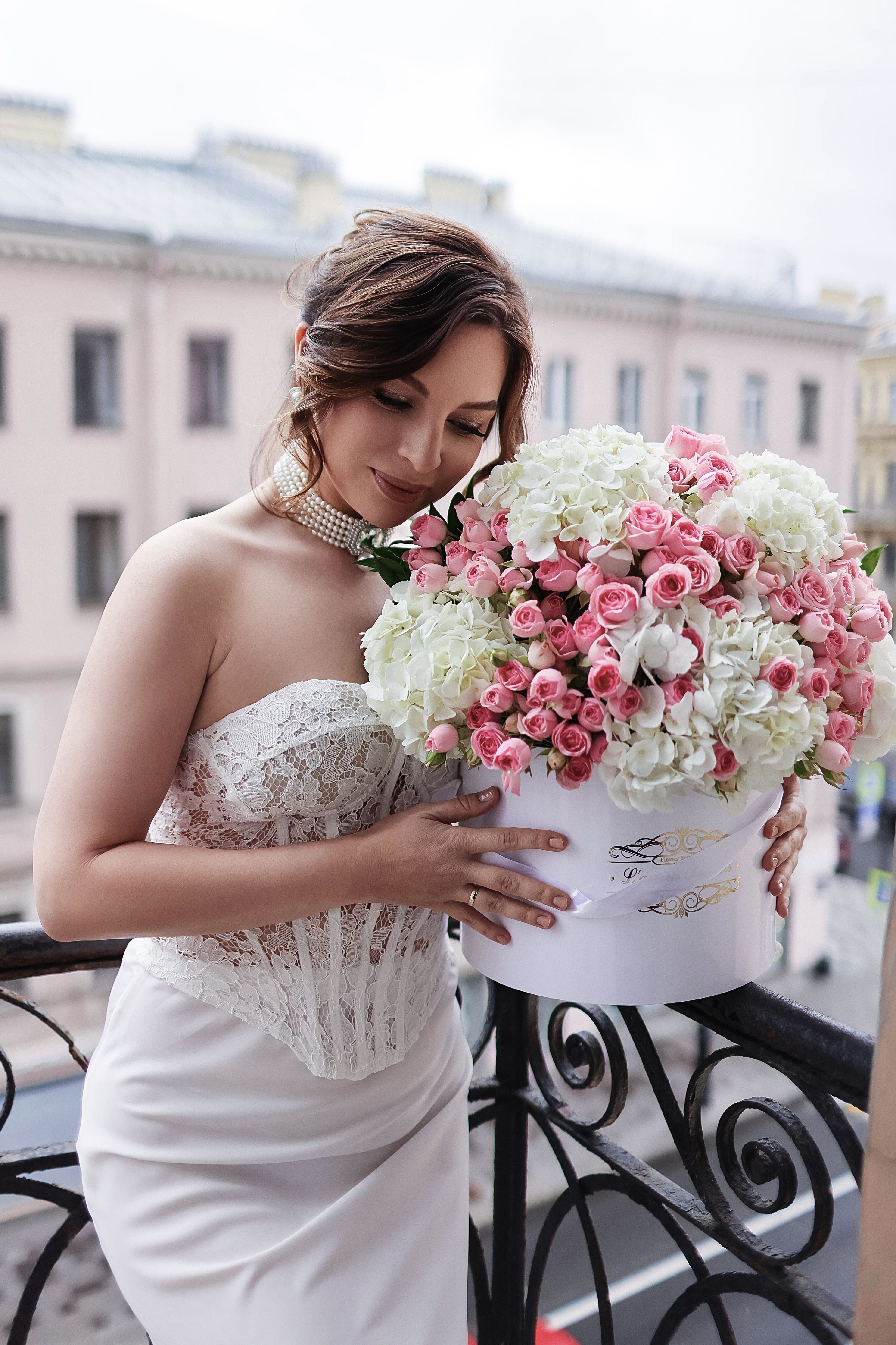 Bride holding a large pink and white rose bouquet in a white box