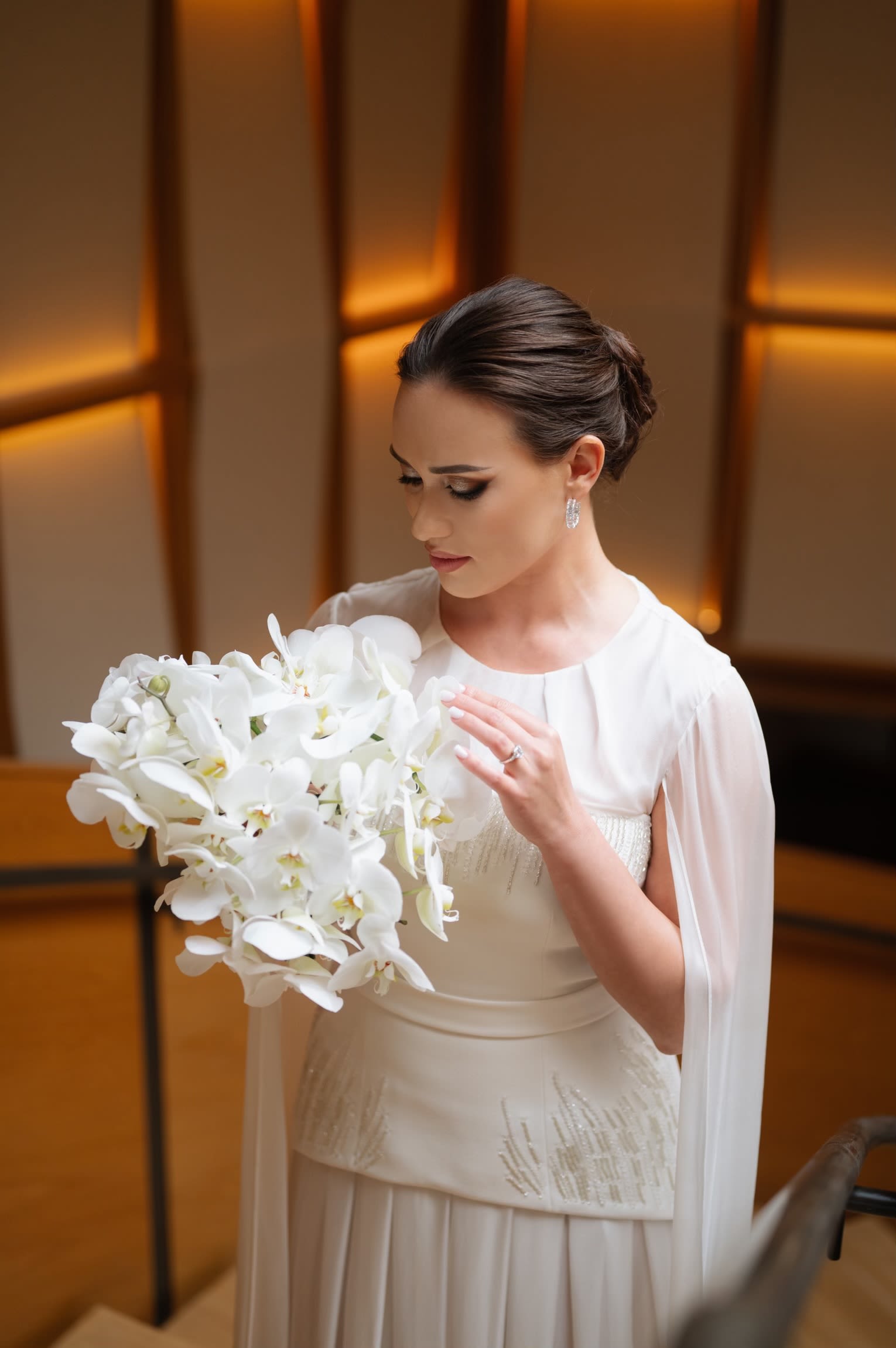 Bride holding a large white orchid bouquet