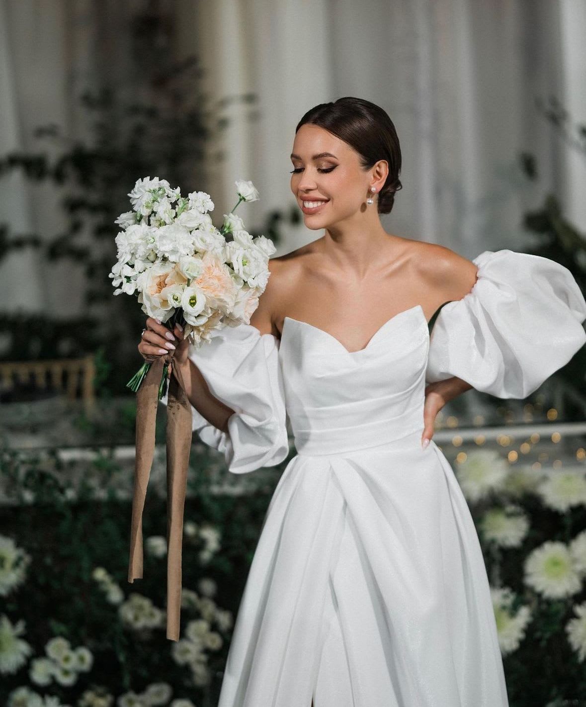 Bride holding a white wedding bouquet with long ribbon streamers