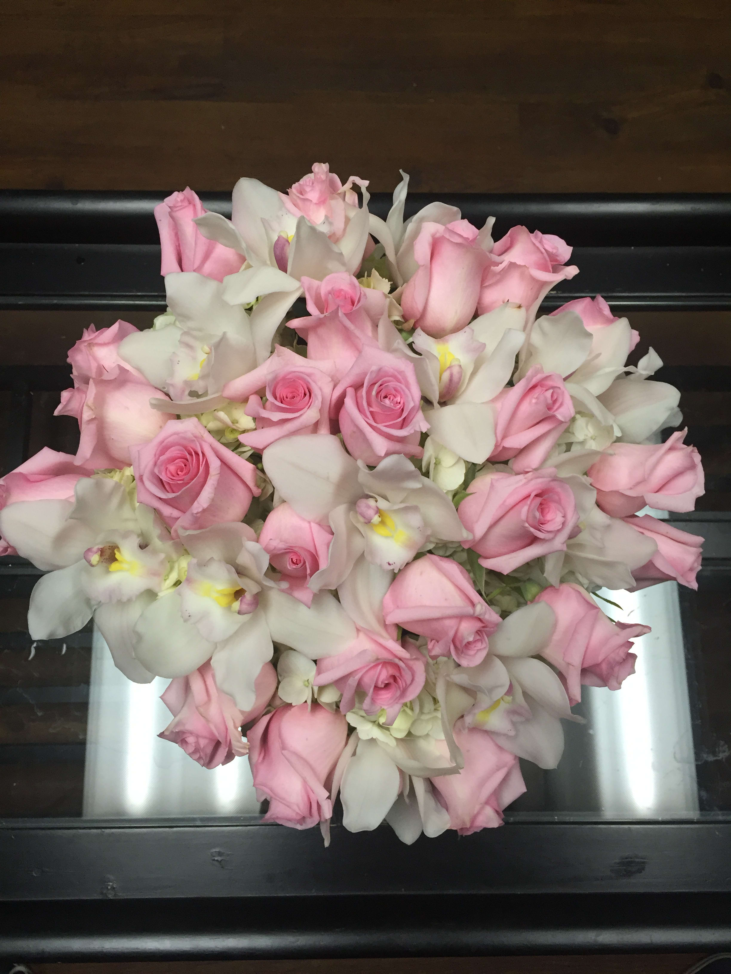 Pink roses and white orchids arranged in a bouquet