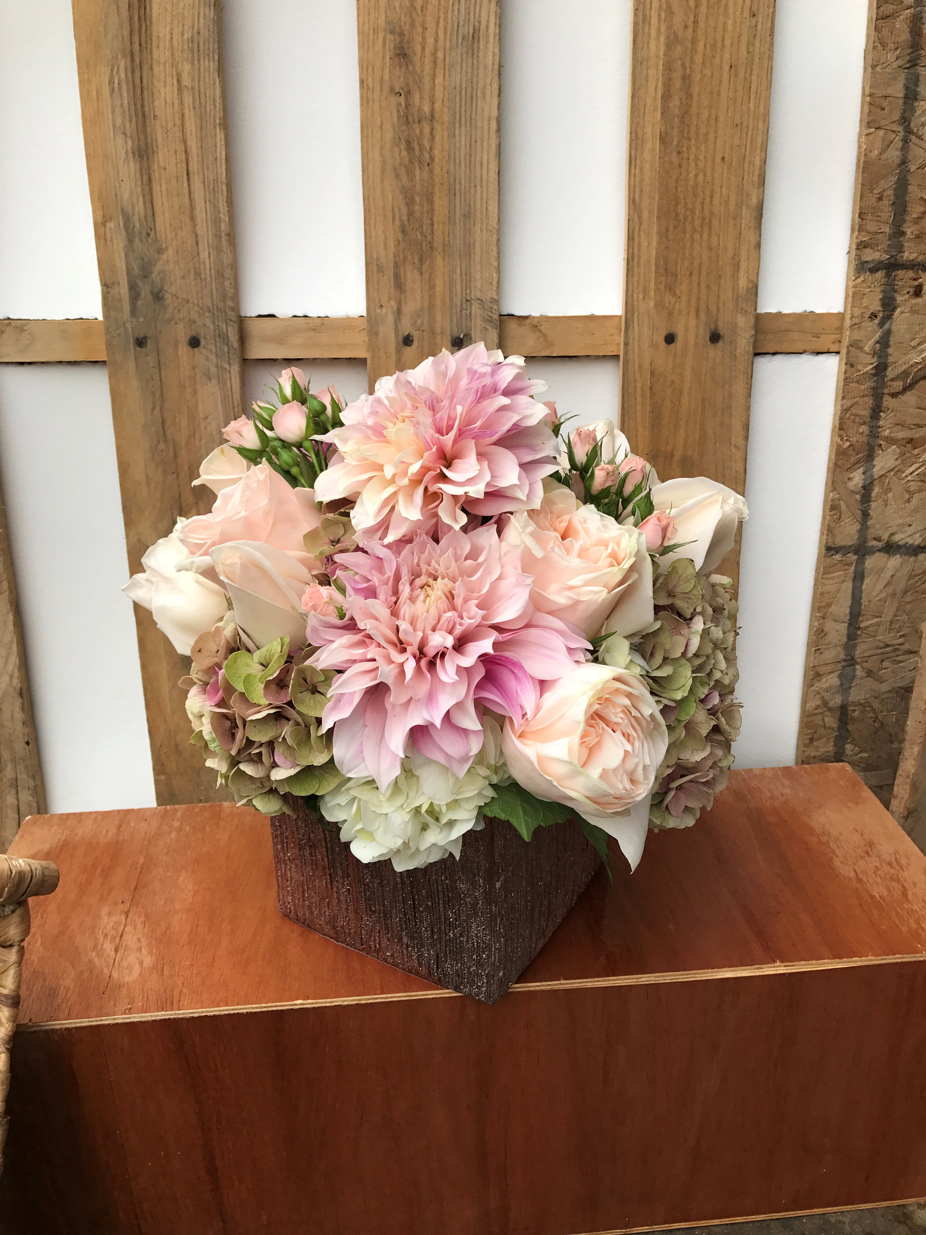 Pink and cream floral arrangement in a textured brown vase