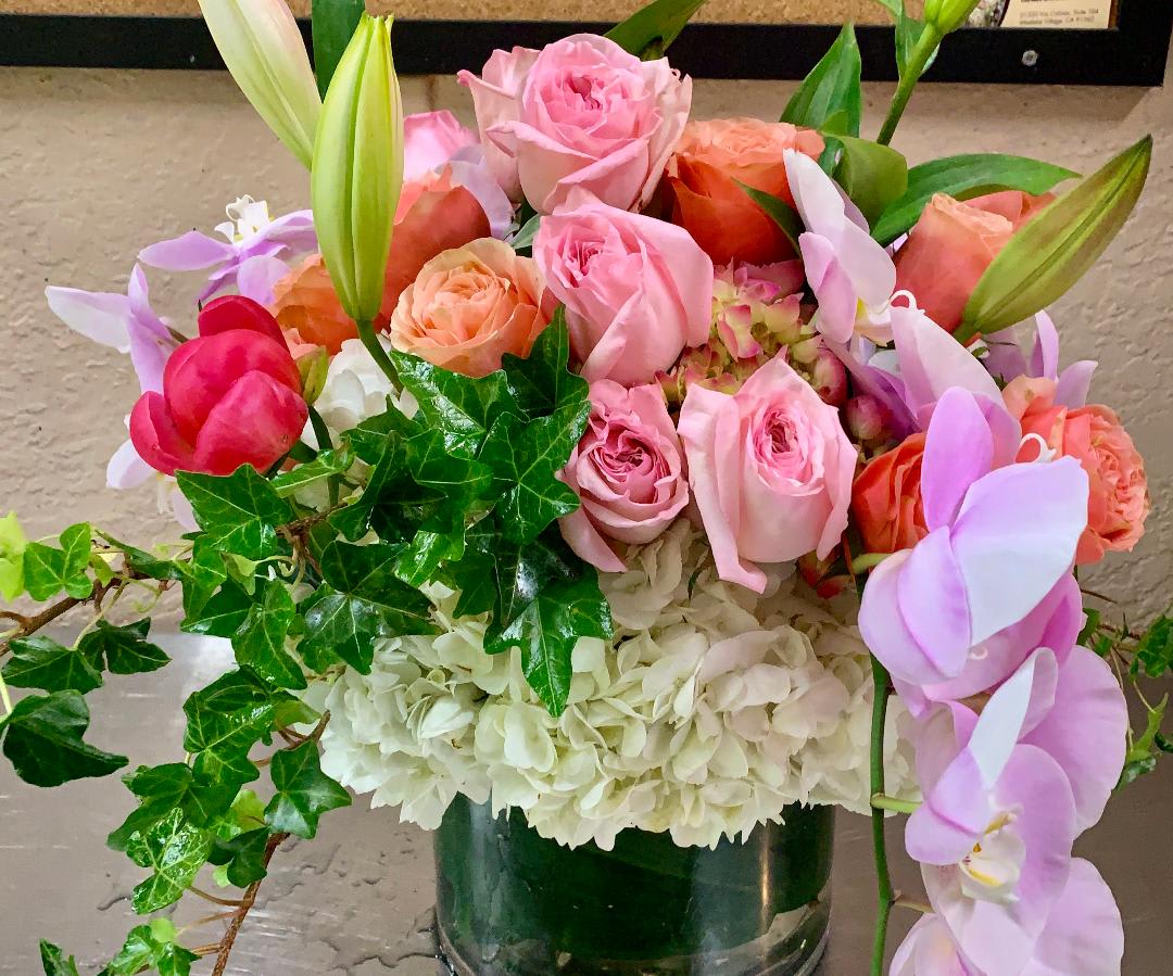 Pink and peach roses with white hydrangeas in a glass vase