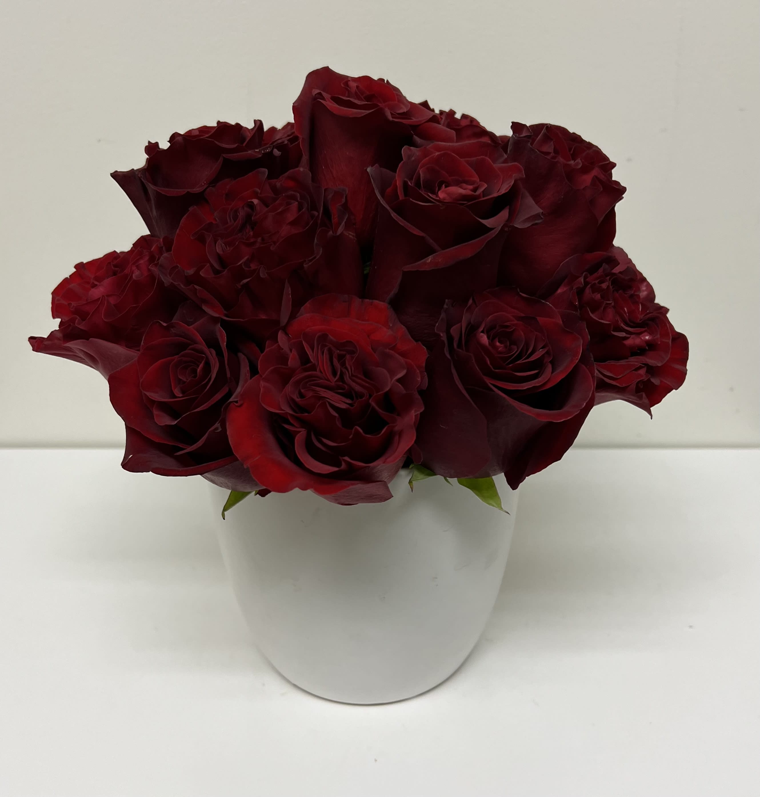 Bouquet of deep red roses in a white vase