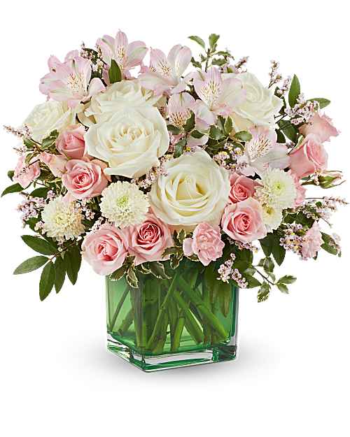 Pink and white roses with alstroemeria in a green glass vase