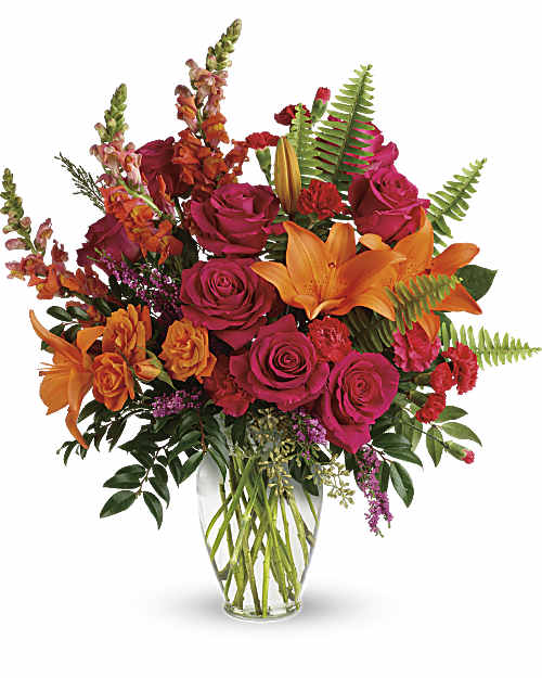 Bouquet of orange lilies and pink roses in a clear glass vase