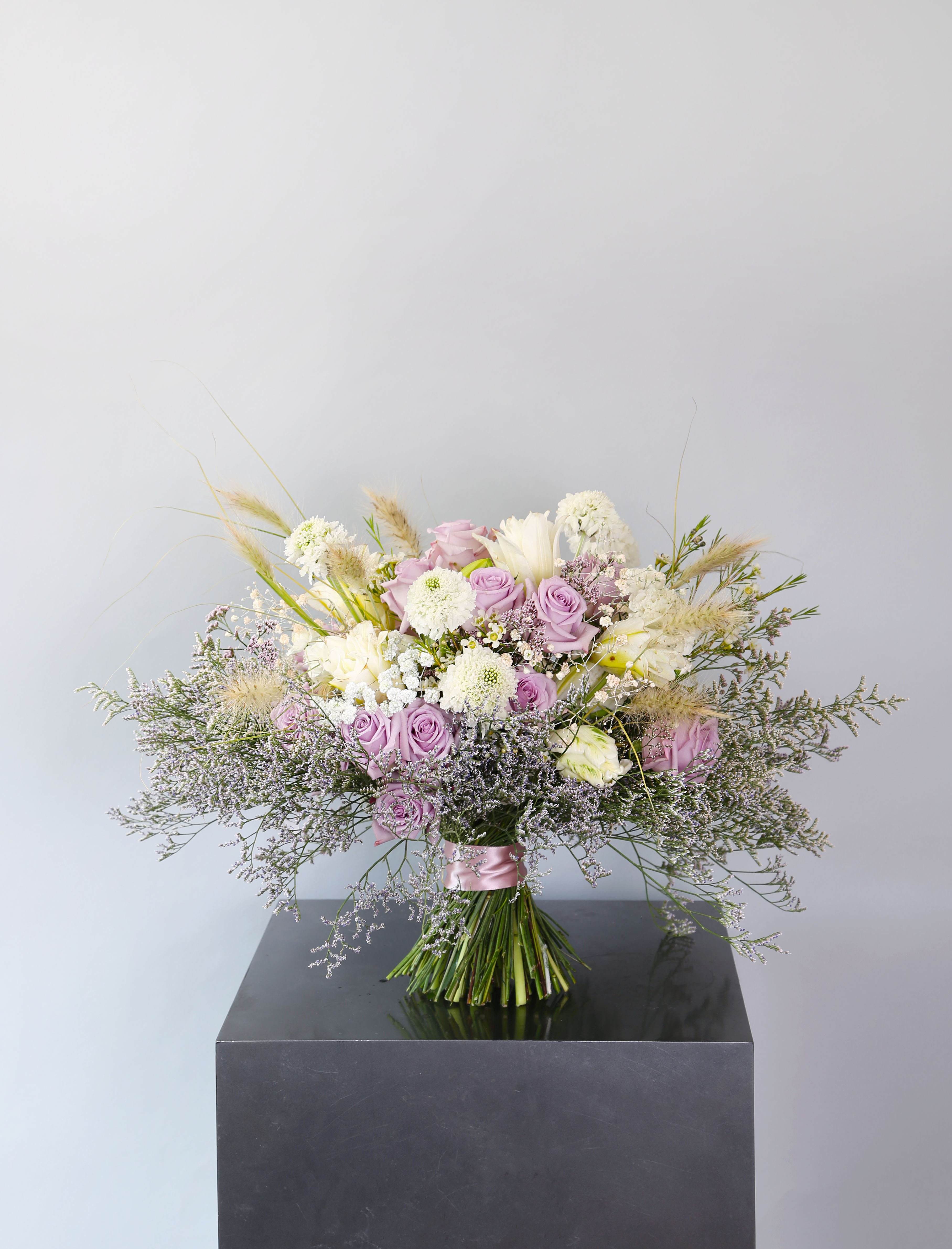 Lavender classic rose - A classic round handtie ribbon wrap bouquet featuring 2 dozen lavender garden rose with ivory tulip and wrap with misty limonium skirt. Simple, clean and classic. This arrangement can be arrange in 8" round vase and deliverd with branded gift box with greeting cards Disclaimer: Photo just represent the overall style, look and feel, which may not be able to identically replicate in some instance. We will only substitute item of equal value or higher value. 