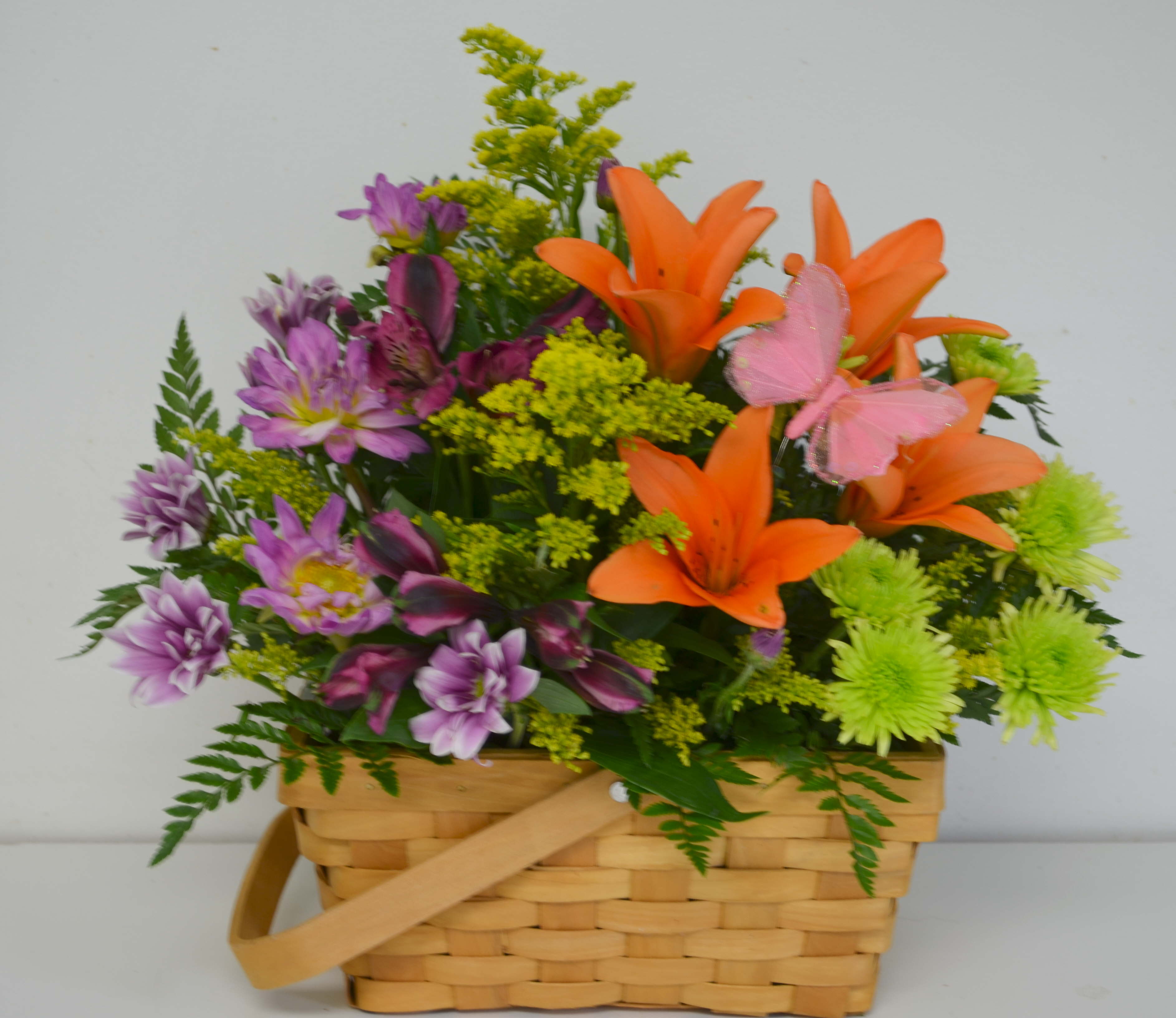 Basket arrangement with orange lilies and purple flowers