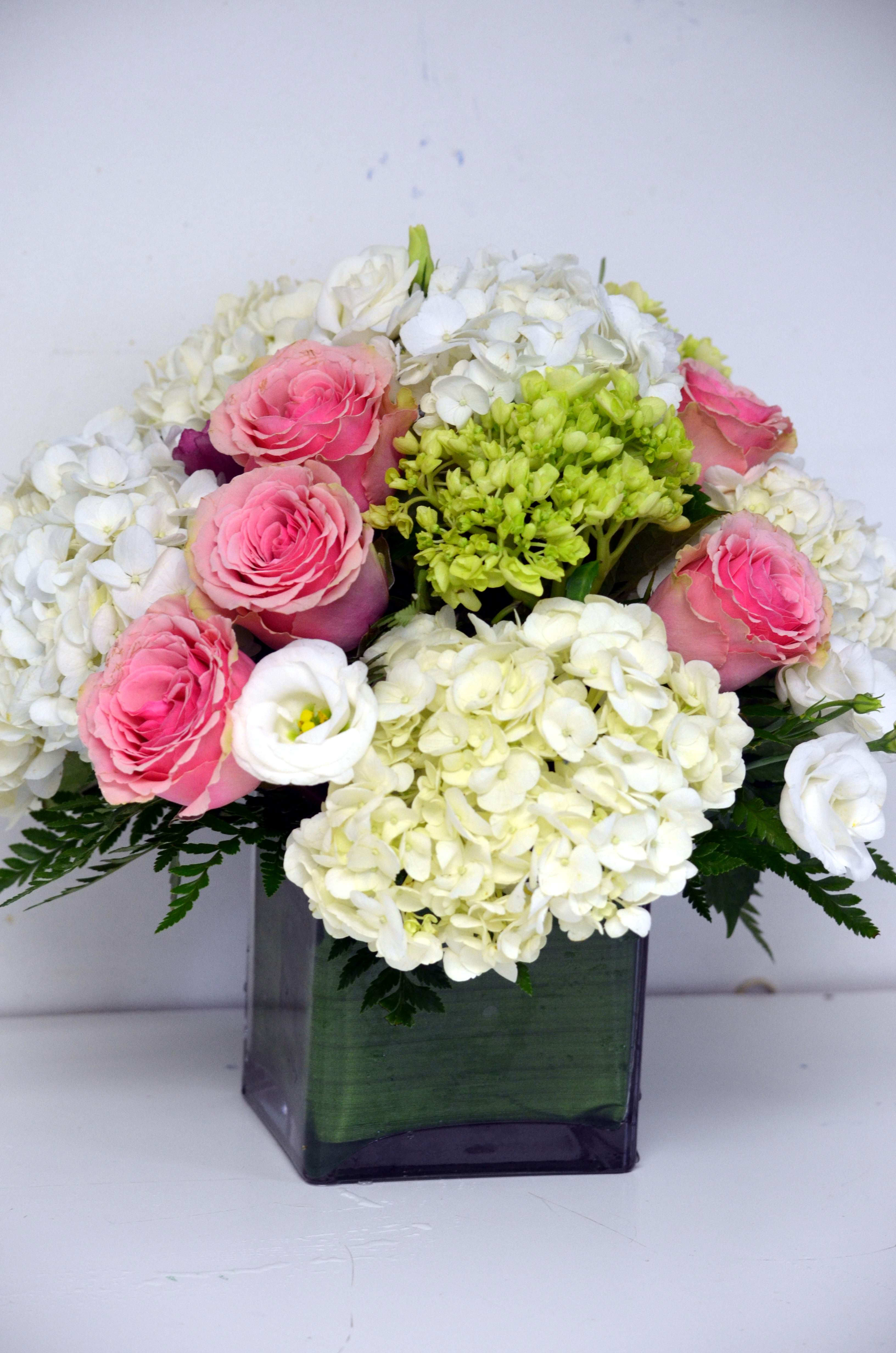Pink roses and white hydrangeas in a square glass vase