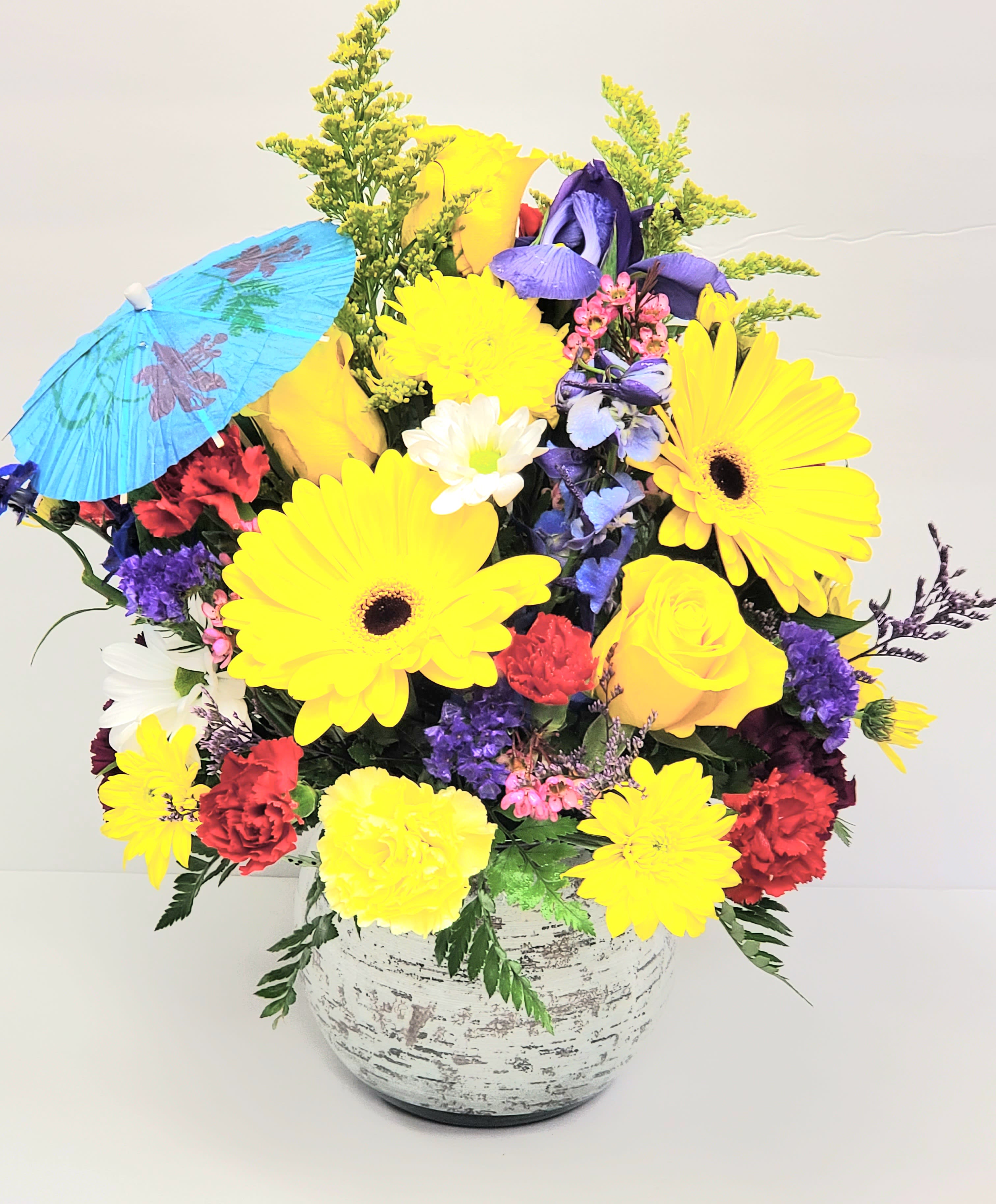 Bright mixed bouquet in a white vase with a blue paper parasol