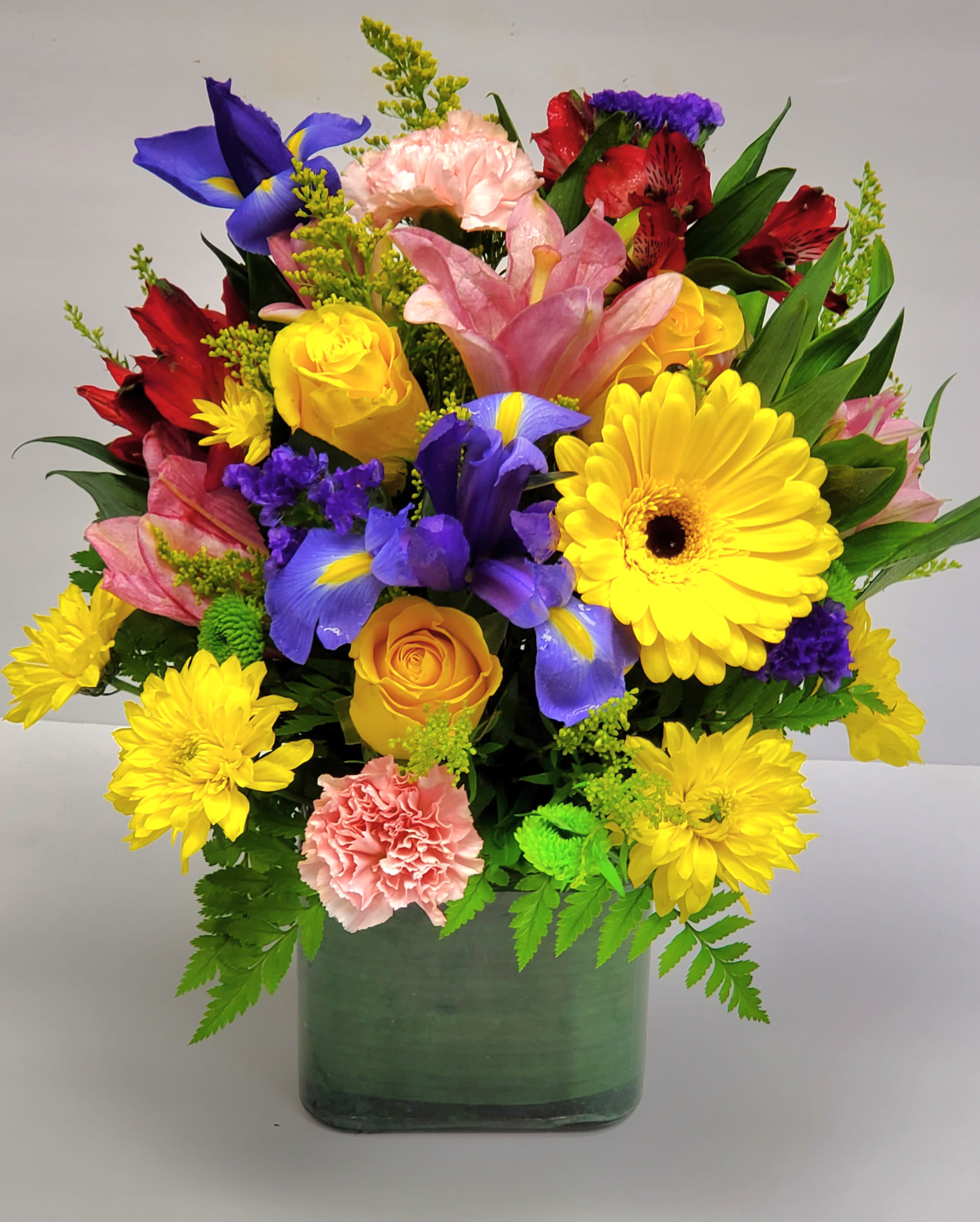 Colorful mixed bouquet in a green square vase