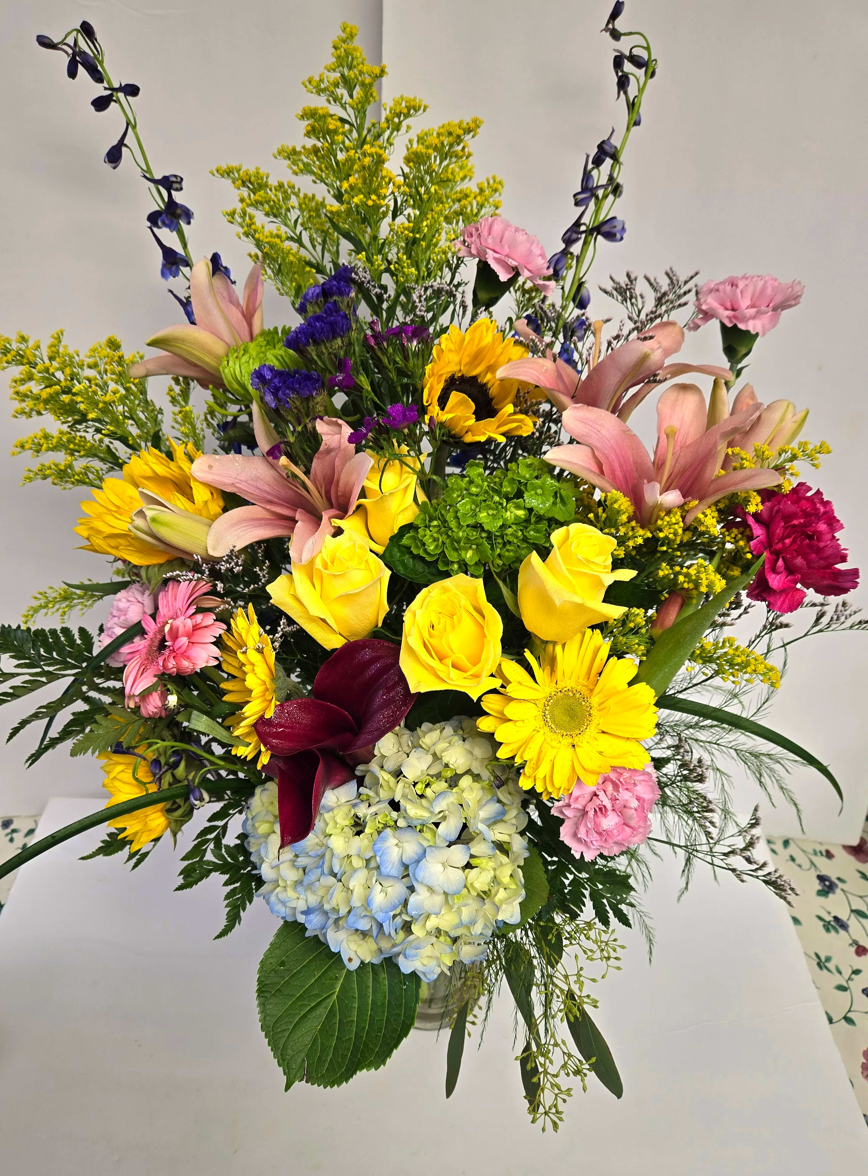 Mixed bouquet with yellow roses, lilies, hydrangea, and daisies