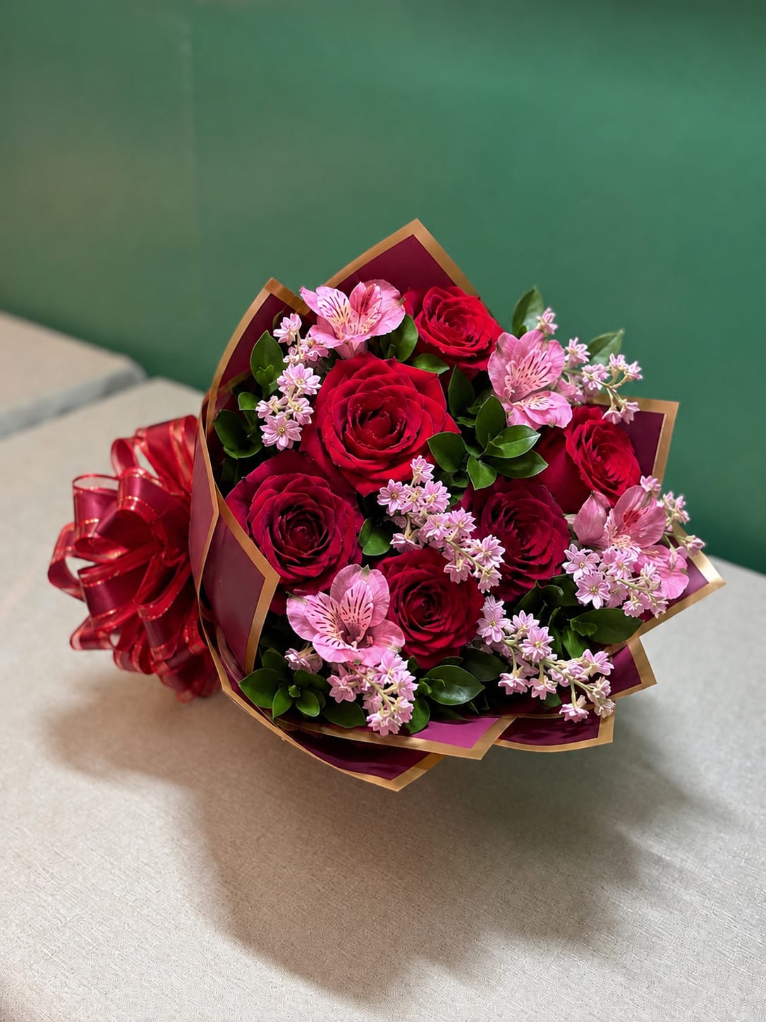 Ruby Bloom Grab &amp; Go - A stunning Grab &amp; Go bouquet featuring vibrant red roses accented with soft pink seasonal blooms, delicate filler flowers, and fresh greenery. Expertly wrapped and ready for gifting, this bouquet is perfect for celebrating love, birthdays, anniversaries, or any special occasion. Flower varieties and accents may vary based on seasonal availability while maintaining the same elegant, handcrafted design. 