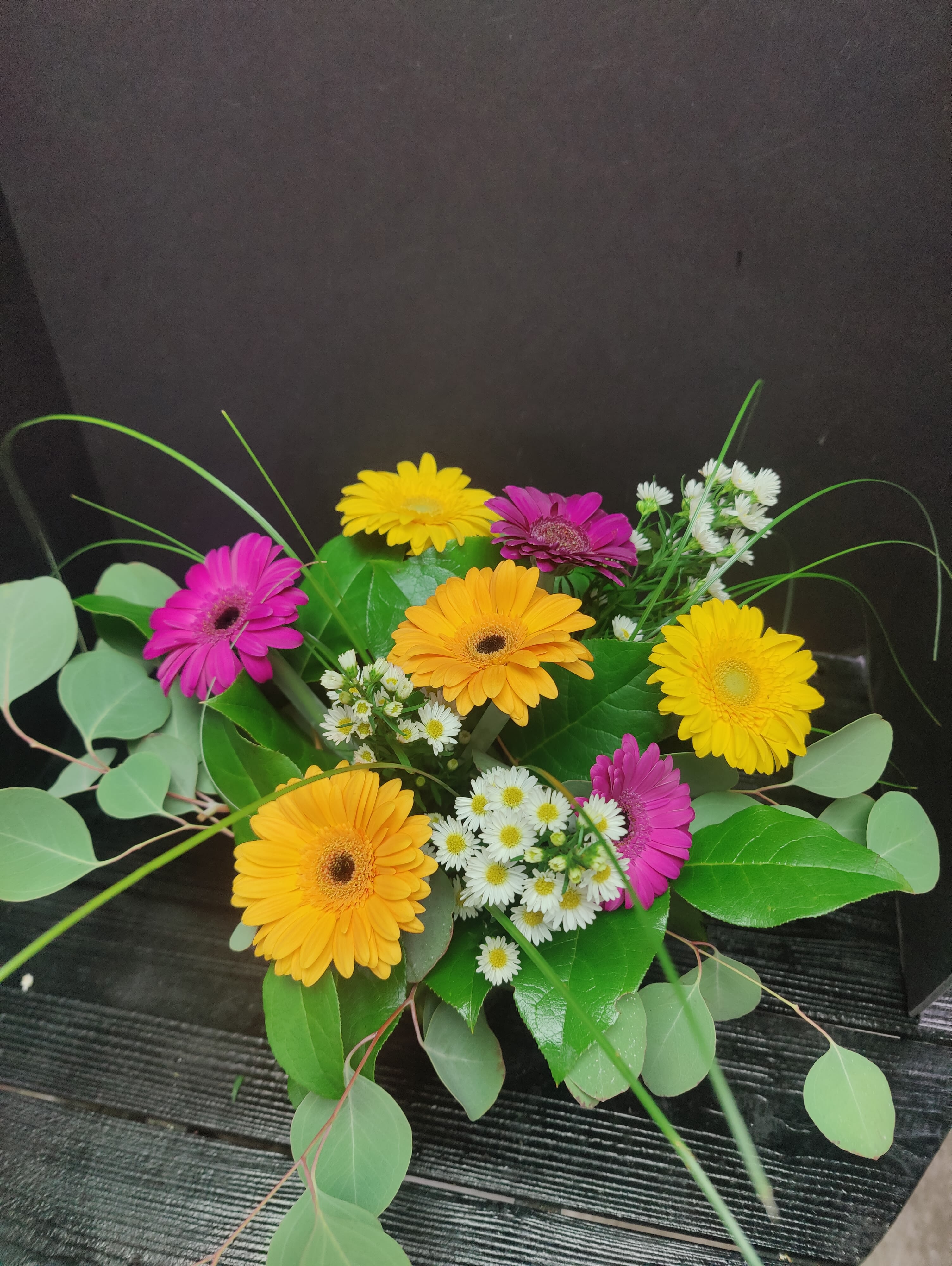 Bouquet of colorful gerbera daisies with small white filler flowers