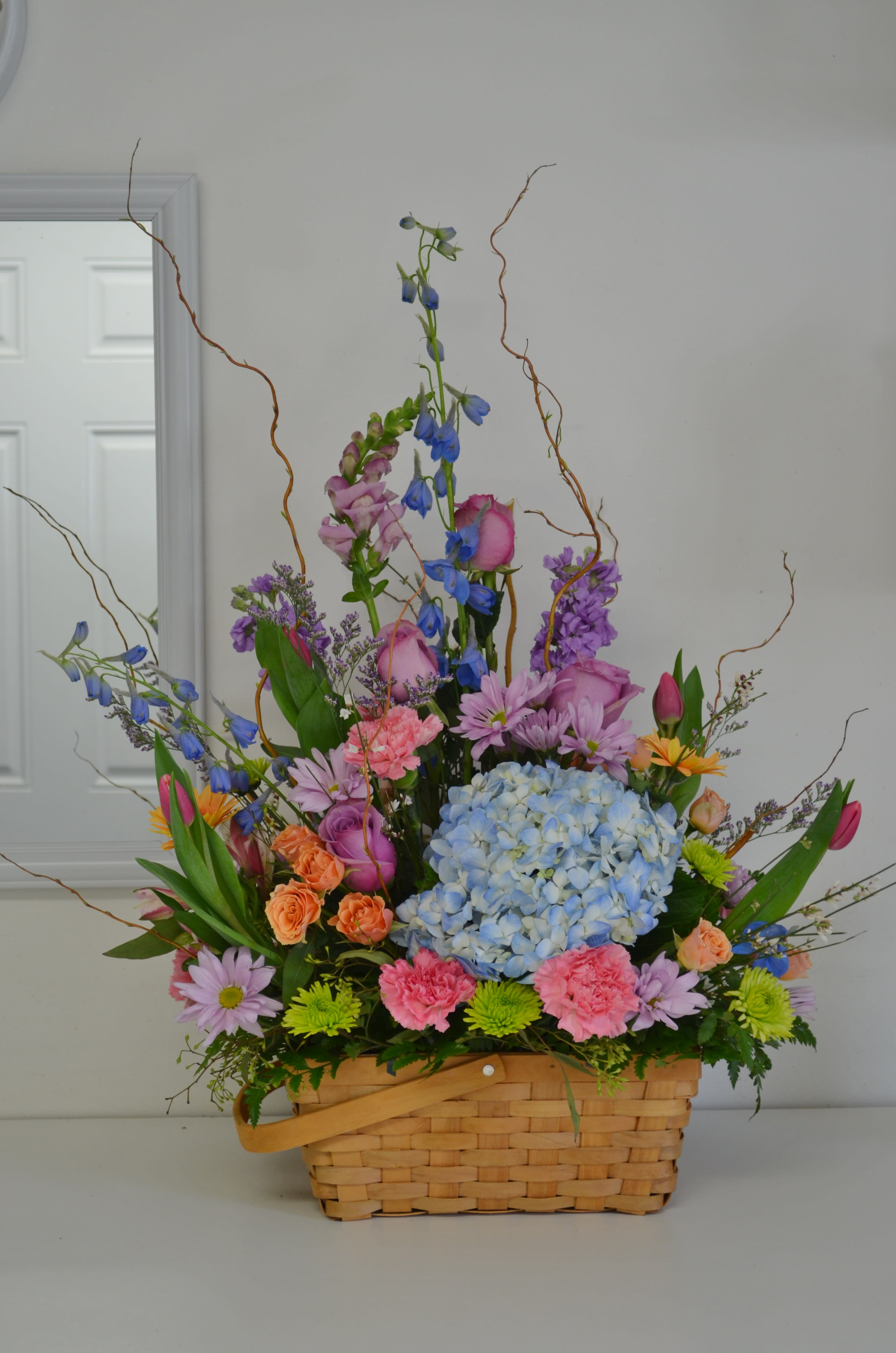Colorful mixed flower arrangement in a woven basket