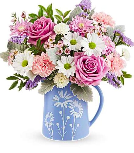 Pastel Meadow - Soft and serene, this Pastel Meadow Bouquet brings the beauty of a blossoming garden indoors with delicate lavender roses and pastel blooms arranged in a blue food-safe pitcher featuring a charming white daisy design. All Around Design Approx. 14 W x 14 1/2 H All Around Design