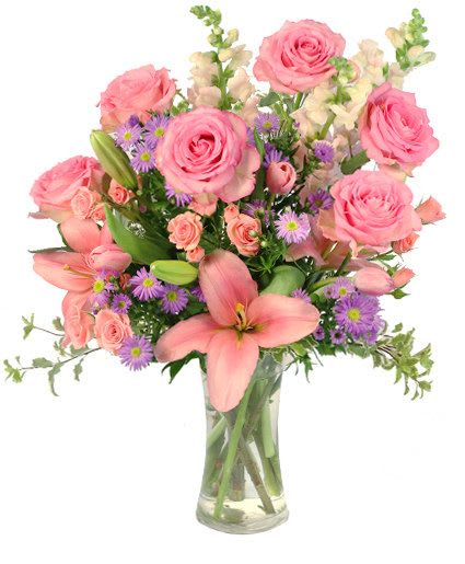 Pink roses and lilies arranged in a clear glass vase