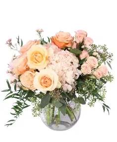 Peach and blush rose bouquet in a clear glass vase