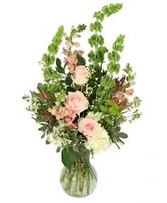 Tall pink and white floral arrangement in a clear glass vase