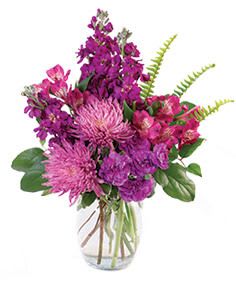 Purple and pink mixed bouquet in a clear glass vase