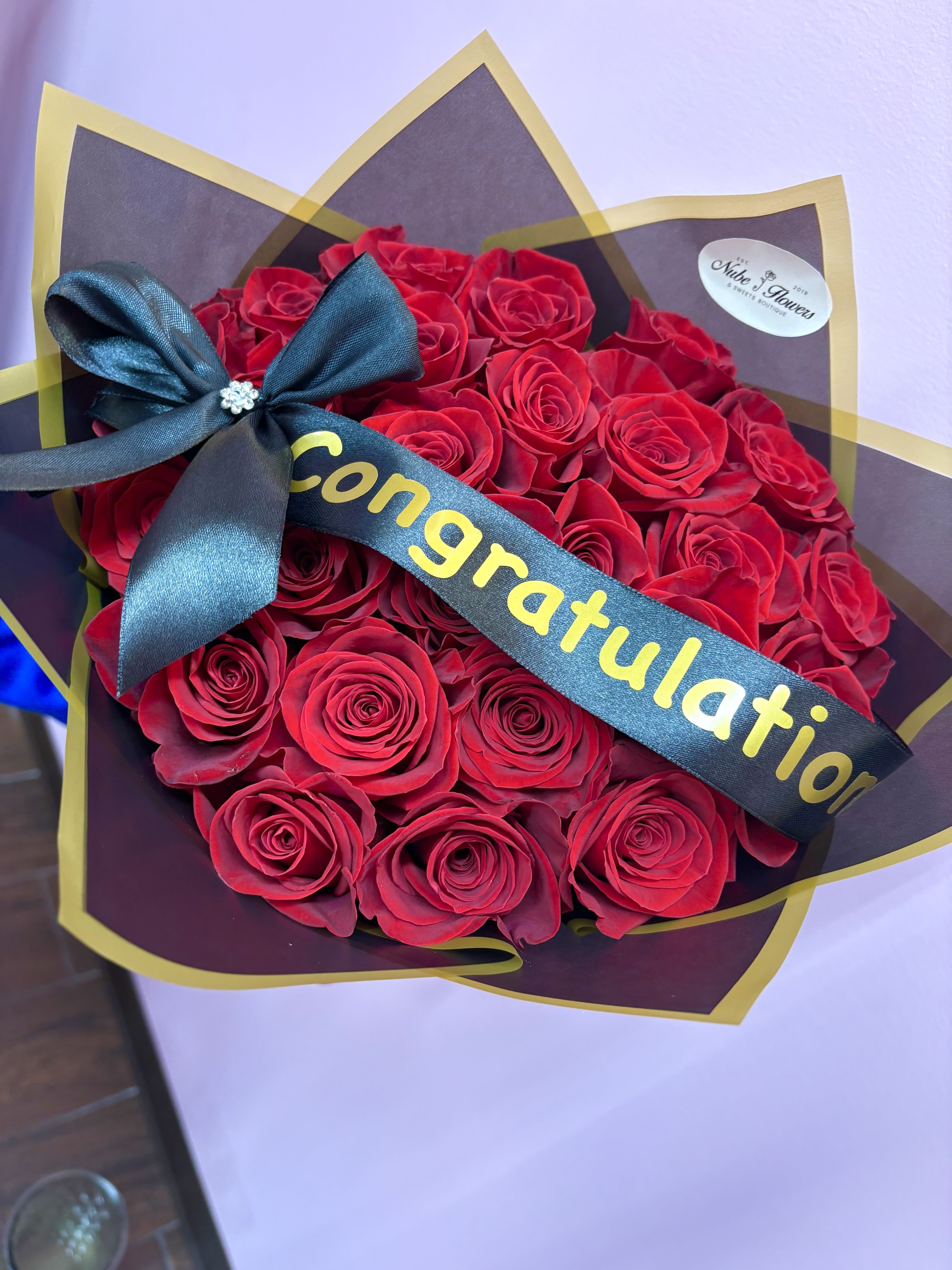 Bouquet of red roses wrapped with a congratulatory ribbon