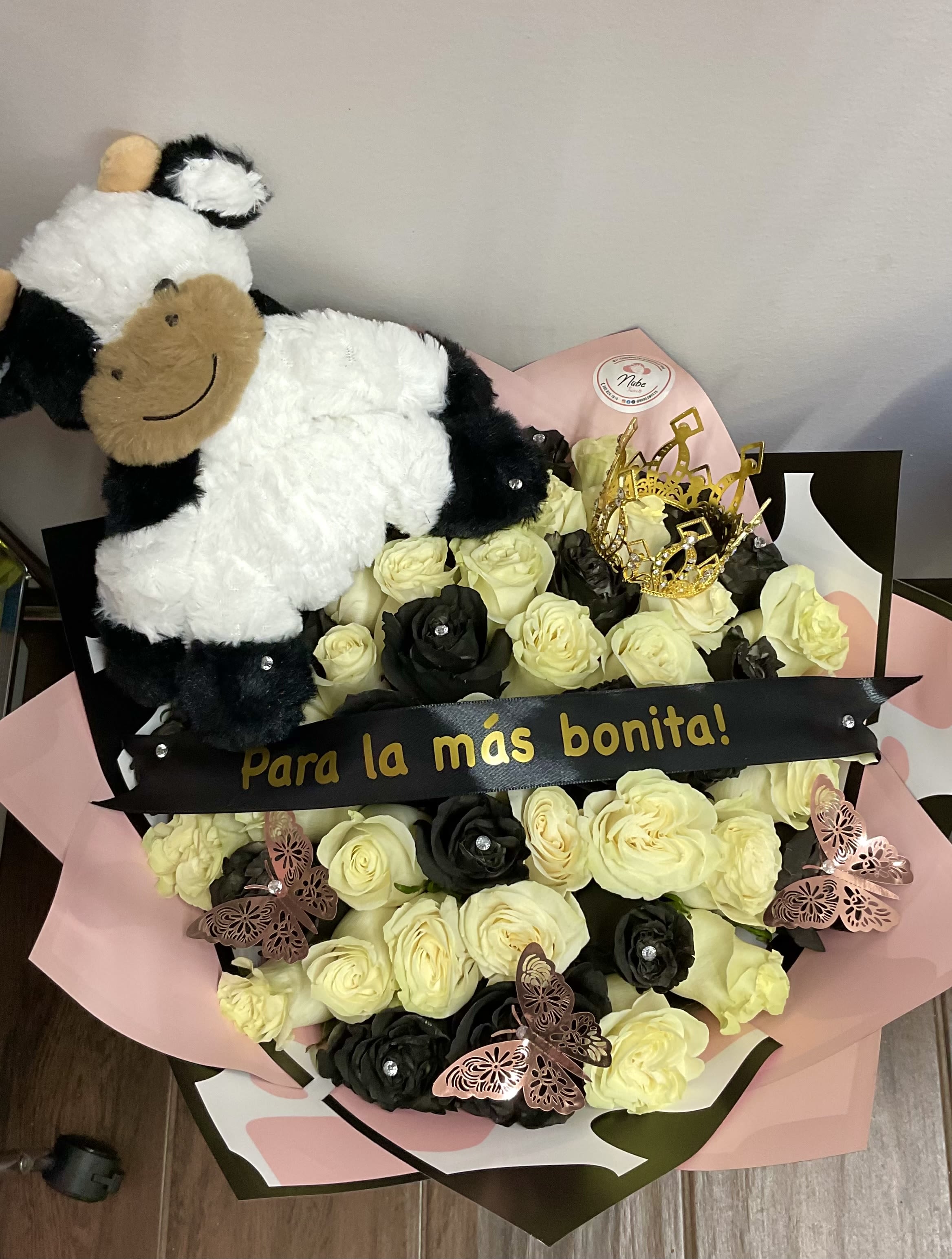 Bouquet of cream and black roses with a plush cow and decorative butterflies