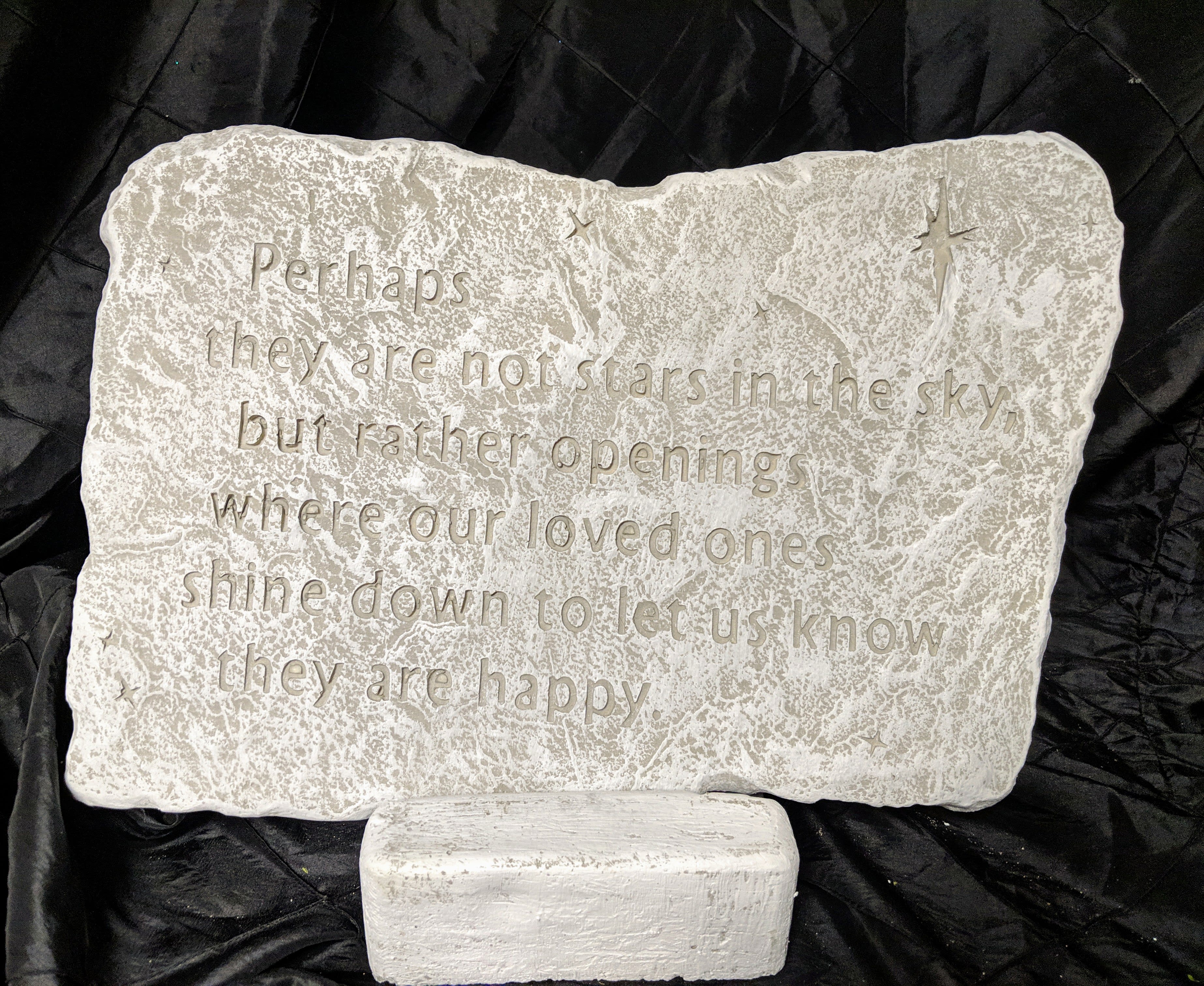Engraved memorial stone with a quote on a stand